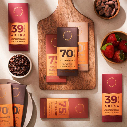 Luxury chocolate bars and packaging styled on a warm tabletop